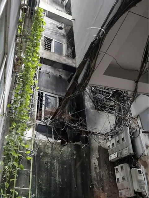 EPA The back of an apartment block after a fire erupted in Hanoi, Vietnam, 13 September 2023.