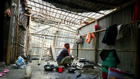 AFP A woman sits in stove in partially destroyed home