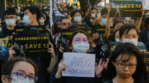 Getty Images Taiwanese and local Hong Kong residents march in Taipei holding placards in support of the 12 Hong Kong democracy activists