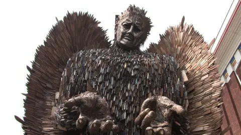 The knife angel. A 27ft-tall (8m) metal sculpture in the shape of an angel with its hands held out, made from 100,000 blades.
