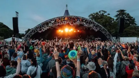 Music fans at the Doune the Rabbit Hole music festival, with their hands in the air