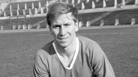 PA A black and white photo of a young Bobby Charlton on the pitch at Old Trafford