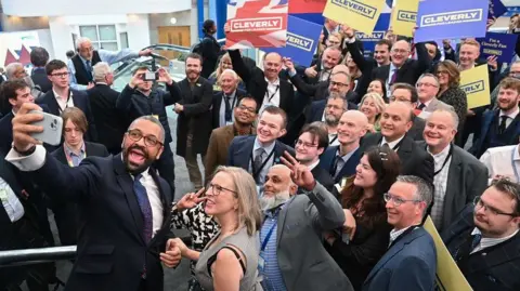 Getty Images James Cleverly takes a selfie with smiling supporters