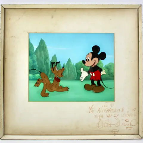 Hansons Auctioneers Pluto and Mickey Mouse in a frames still from a cartoon. The image is framed with an inscription and a signature from Walt Disney on the mount.