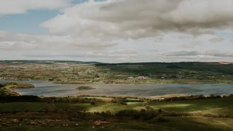 Getty Images A rural landscape in County Fermanagh. Green fields and trees surround Lough Erne. 