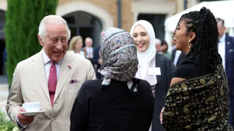 King Charles meets staff during a visit to the Oxford Centre for Islamic Studies in Oxford.