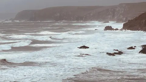 Bigbury sea during Storm Bert in 2024. The waves are choppy and there are rocks in the distance.