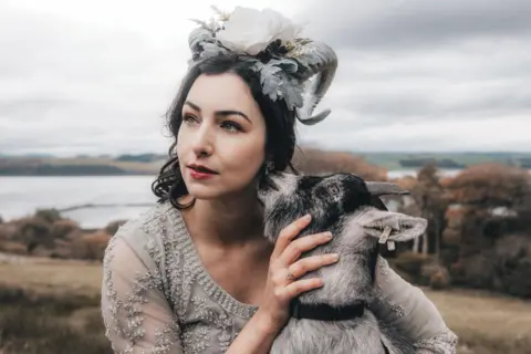 IRH Photography Chloe has shoulder length dark hair and flowers and goat horns on her head. 