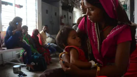 Getty Images An indian child, suffering from AES (Accute Encephalitis syndrome) gets treatment outside of ICU (Intensive Care Unit ) as a garbage trolly passes through patients at SKMCH (Sri Krishna Medical college and Hospital ) Muzaffarpur on June 23, 2019 .