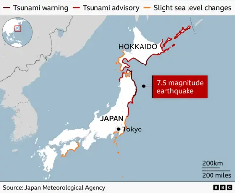 Map of Japan labelled with Hokkaido and Tokyo, showing coastal tsunami warnings issued after a 7.4 magnitude earthquake. Black coastal lines indicate tsunami warnings, red lines show tsunami advisories and orange lines mark areas of slight sea level changes.