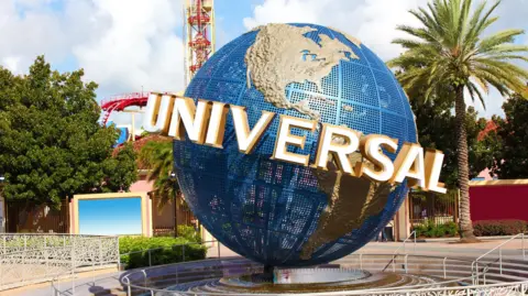 Getty Images A view of the Universal globe outside the entrance to the Florida park. A roller-coaster and other rides can be seen in the background.