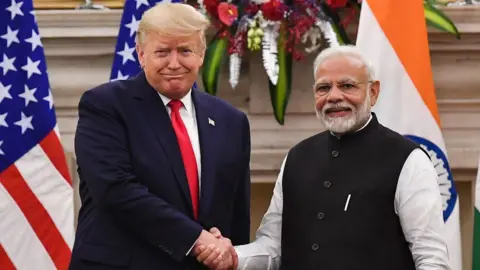 India's Prime Minister Narendra Modi (R) shakes hands with US President Donald Trump before a meeting.