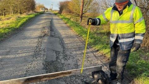 Danny Lee measuring potholes