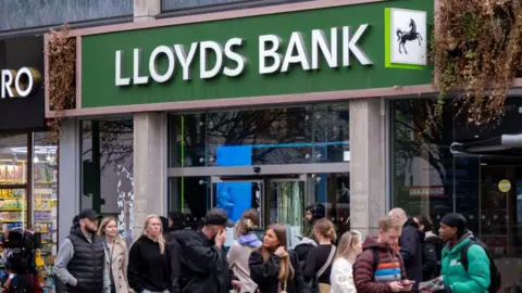 Getty Images People gathered outside a Lloyds Bank branch 