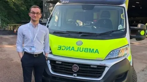 East of England Ambulance Service Tom Abell in front of ambulance