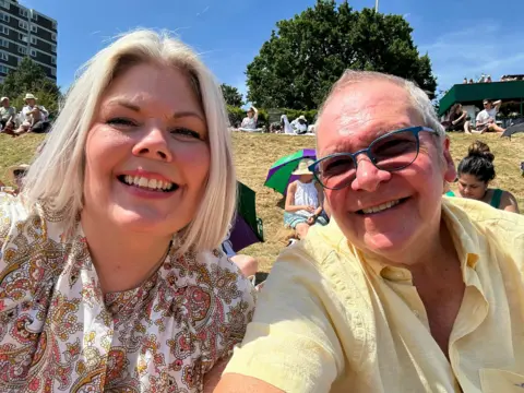 Supplied Fan Nigel is sitting on Henman Hill taking a selfie with his wife Caroline 