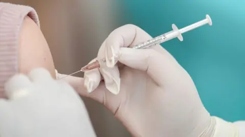 A vaccine going into someone's arm