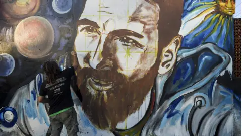 AFP / Getty Images  Artist Lisandro Urteaga paints a mural of Lionel Messi in Rosario