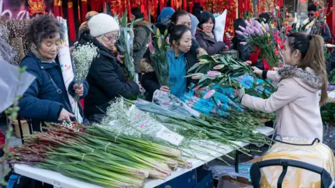 Getty Images People rush to buy flowers ahead of New Year in 2019