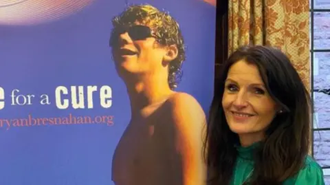 Charlotte Bresnahan Michelle and a board with a photo of Ryan on it alongside white writing on a blue background.