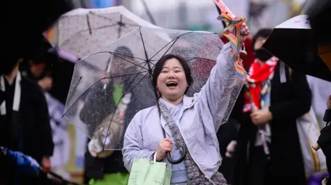 Woman holding an umbrella under the rain during a protest in Seoul, South Korea