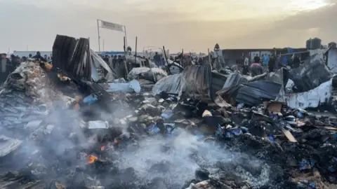 Smouldering remains of refugee camp