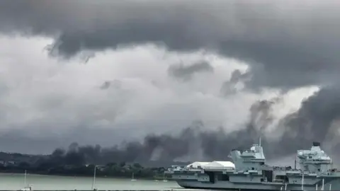 KATHERINE FLOYD Black smoke pouring over the marina from behind trees 