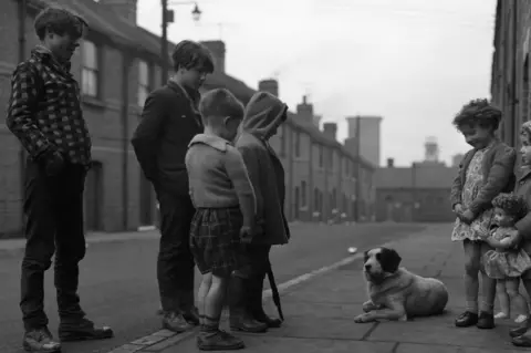 Getty Images Children and a dog on a street in Middlesbrough in 1964