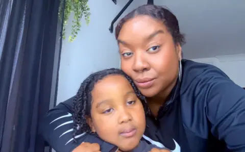 Family photo Alicia Samuels has her arm around her young son Aeon and they are both looking directly at the camera