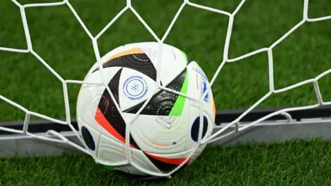 Getty Images Football in net on grass