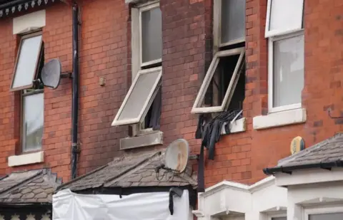 PA Media/Peter Byrne House damaged by a severe fire with the upstairs windows blow out