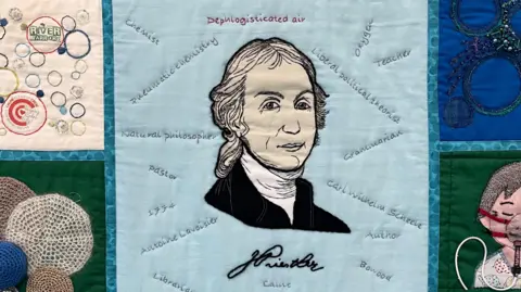 An image of Joseph Priestley on a blue patchwork quilt 