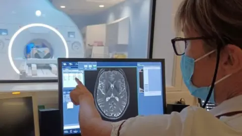 Cambridge University Hospitals Hospital staff member checking MRI images