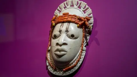 A 19th-century ivory, ceremonial hip mask in honour of Queen Mother Idia and looted by British soldiers from the Kingdom of Benin in 1897 hangs on display in the "Where Is Africa" exhibition at the Linden Museum on May 05, 2021 in Stuttgart, Germany