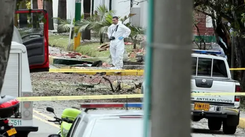 EPA Members of the Colombian Technical Investigation Team (CTI) work at the place where a bomb car caused an explosion