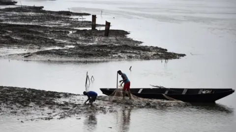 AFP Nigerian fisherman work on a river blackened by oil pollution