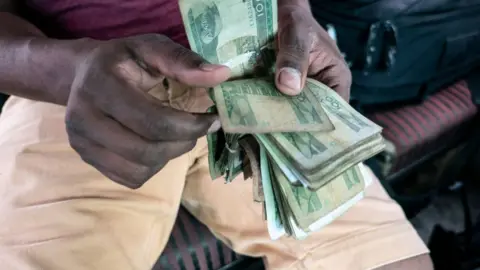 Getty Images Man counting local Ethiopian currency birr notes