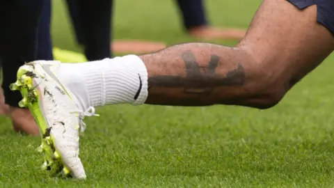 Getty Images Picture of the tattoo of a gun on Raheem Sterling's leg