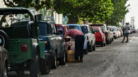 Getty Images Drivers queue to get fuel near a gas station in Havana