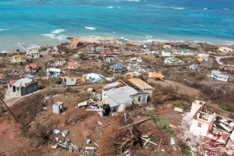 Reuters A birds-eye view of a hillside shows smashed houses leading to the sea