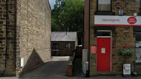 Google Maps A brick house can be seen down a narrow drive way. On one side of the driveway is a red door which appears to be a shop and on the other is a house. The bungalow is set back off the road. This is the Dorset Avenue property as seen on Goggle Maps prior to the incident.