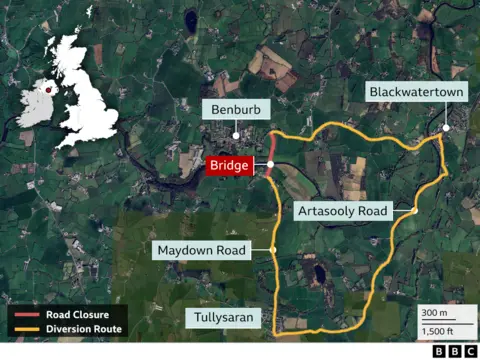 A map showing the area of Benburb and Tullysarran. In red the short road closure over the bridge is marked. In yellow a much longer route shows the diversion between Tullysaran and Benburb, heading south and then looping to the east through Blackwater town before coming back west to Benburb.