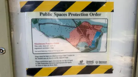 A map of Lydiard Park that has been stuck to a white surface with black and yellow zigzag tape and the words "public spaces protection order" written on it.