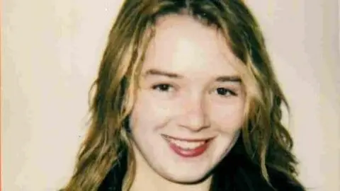 TVP A grainy photograph of Sabrina Brett, who has long blonde hair and is smiling. She is wearing a black top, although only the top part of it can be seen in the image.