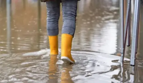 Getty Images A person in yellow boots walking in the rain