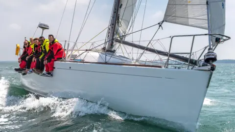 Shaun Roster A crew on a yacht sailing in the sea 