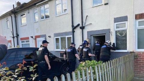Officers raiding a house