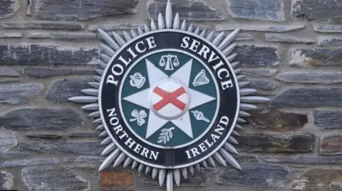 PA Media Police Service Northern Ireland (PSNI) crest on a wall 