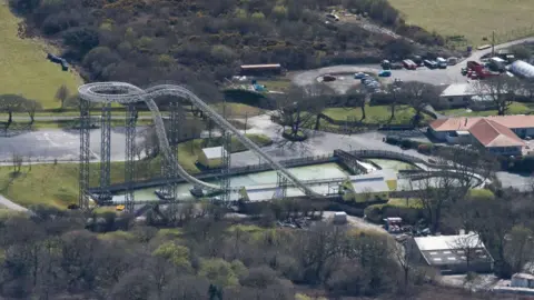 An aerial view of the ride Drenched (formerly Hydro) at Oakwood Theme park in Pembrokeshire on April 9, 2016 in Narberth, United Kingdom. The theme park is home to rides including Megafobia, Vertigo and Speed. There are trees surrounding the buildings and rides. 