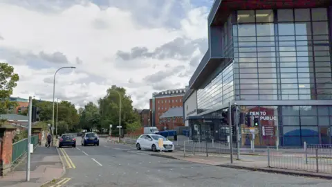 A street scene with cars on a road 